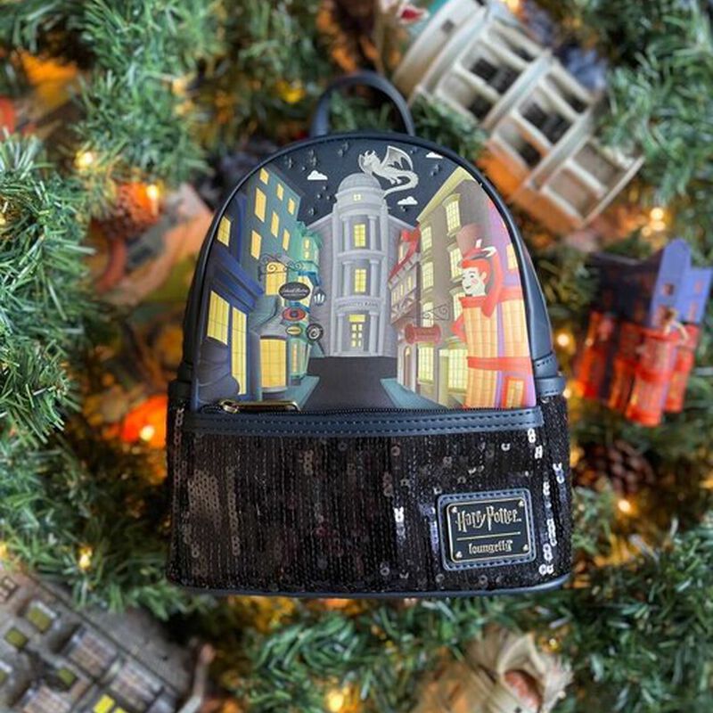 Image of the Diagon Alley Sequin Mini Backpack against a wreath of pine needles with fairy lights around it 